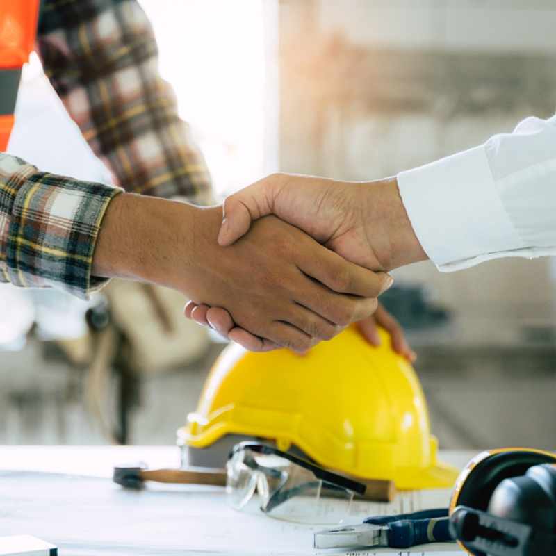 construction worker and contractor. Client shaking hands with team builder in renovation site.